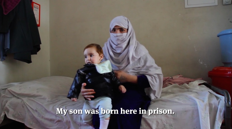 Afghan mother with son who was born in prison, scene from documentary film “To Kill A Sparrow”