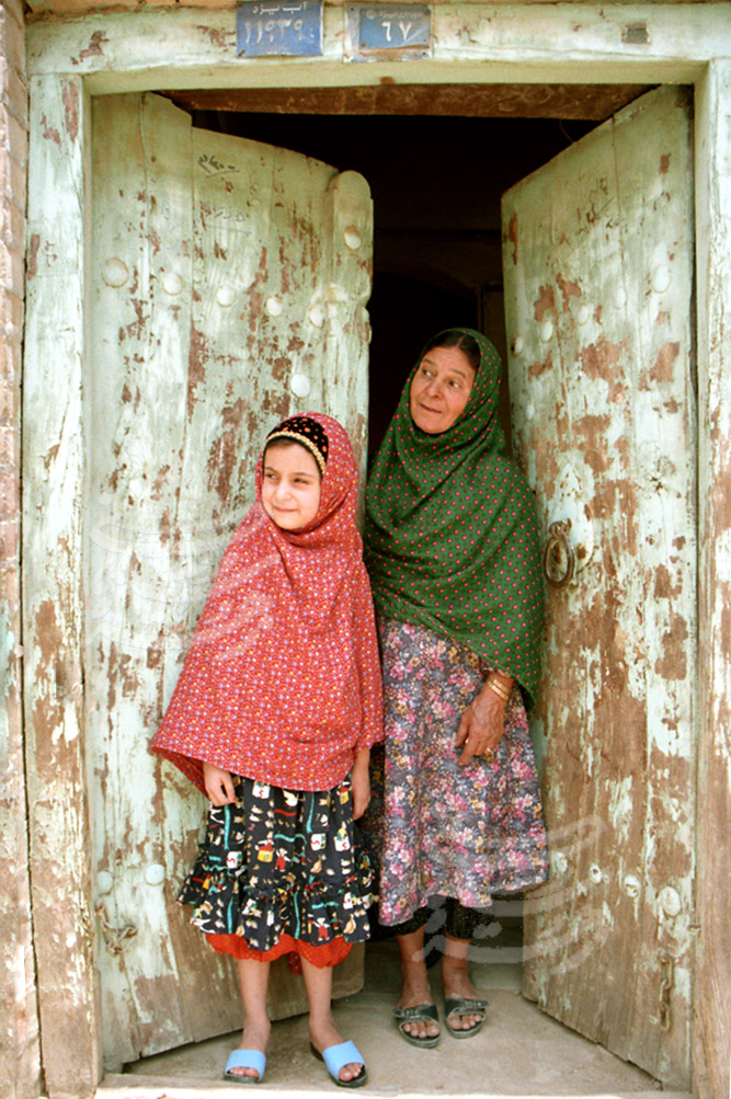 Zoroastrians in Iran: grandmother and granddaughter standing in a door